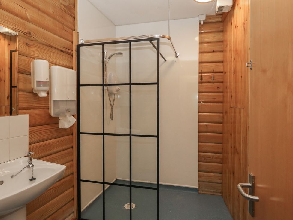 A bathroom with a shower and sink at Shore Lodge in Brodick
