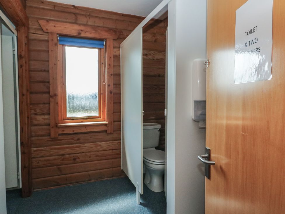A bathroom with a toilet and a window at Shore Lodge in Brodick