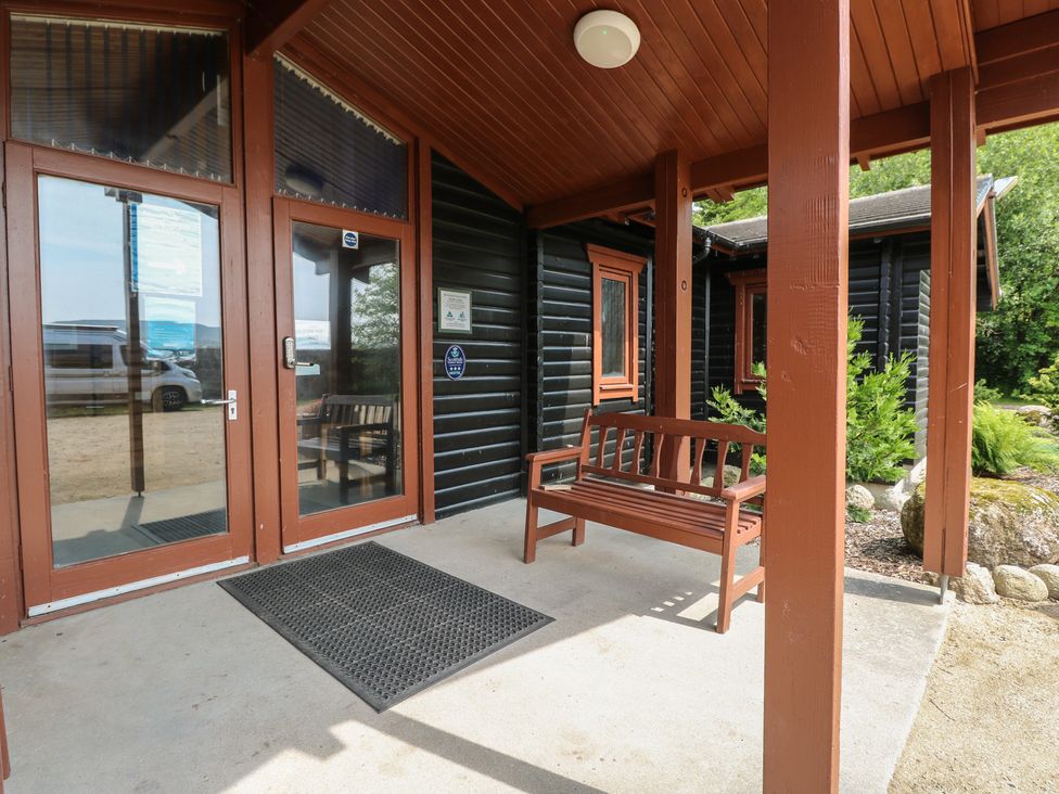 An exterior entrance with double doors and a bench at Shore Lodge in Brodick