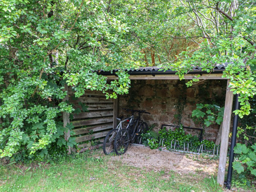A bike shelter with bicycles and a bike rack at Shore Lodge, Brodick