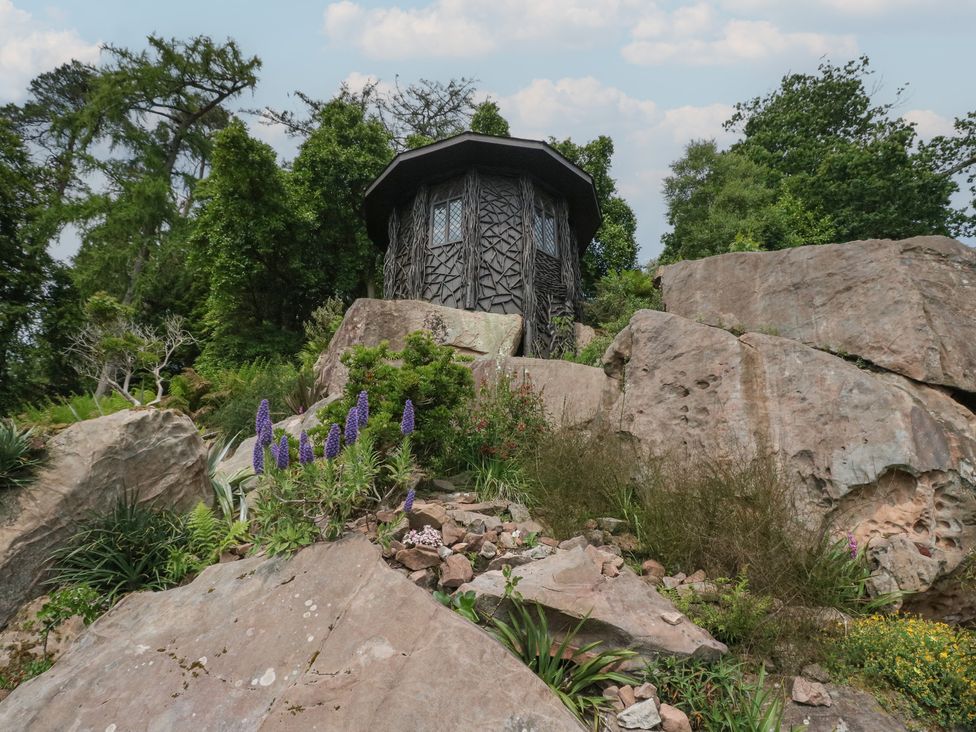 A house surrounded by rocks and plants at Shore Lodge in Brodick