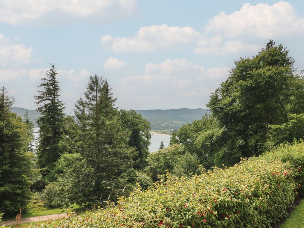 A view of trees and water with hills in the background at Shore Lodge in Brodick