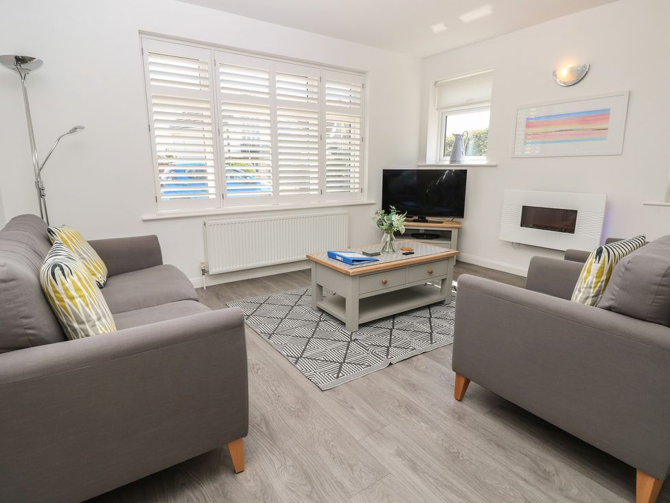 A living room with sofas and a television at 50 Sea Road in Milford On Sea