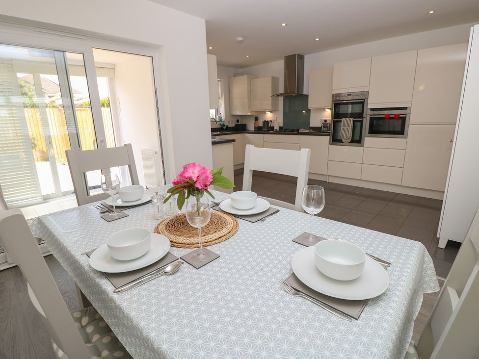 A dining room with a table set for four at 50 Sea Road Milford On Sea
