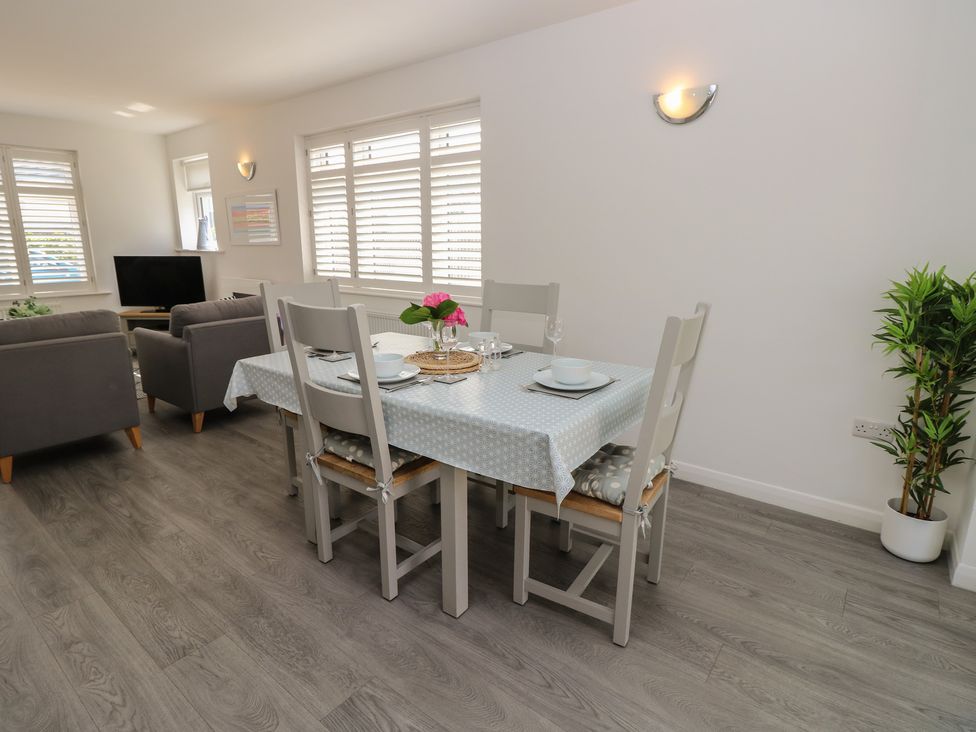 A dining room with a table and chairs at 50 Sea Road Milford On Sea