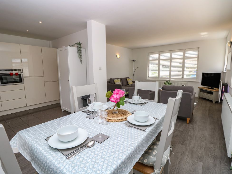 A dining room with a table set for a meal at 50 Sea Road Milford On Sea