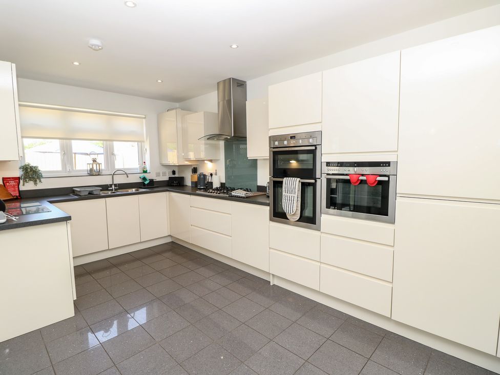 A kitchen with cabinets and appliances at 50 Sea Road in Milford On Sea