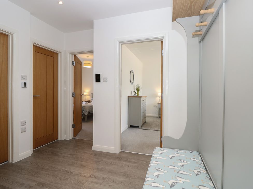 A hallway with a bench and doors at 50 Sea Road Milford On Sea