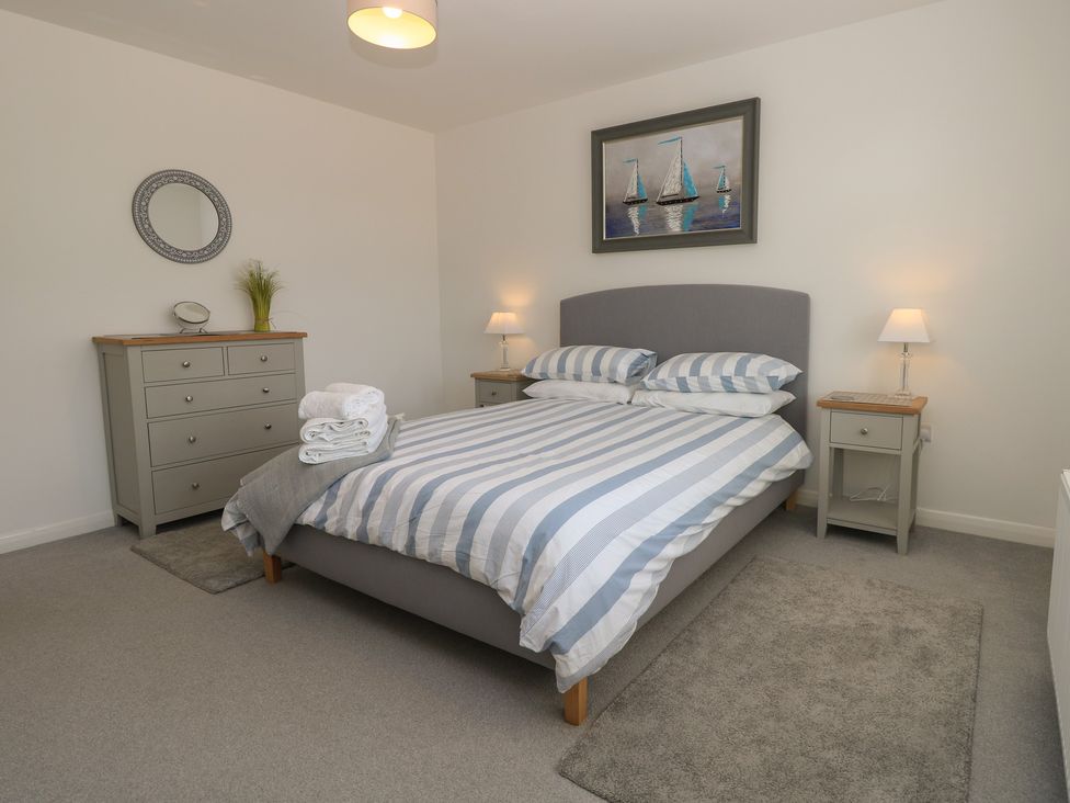A bedroom with a bed and dresser at 50 Sea Road Milford On Sea