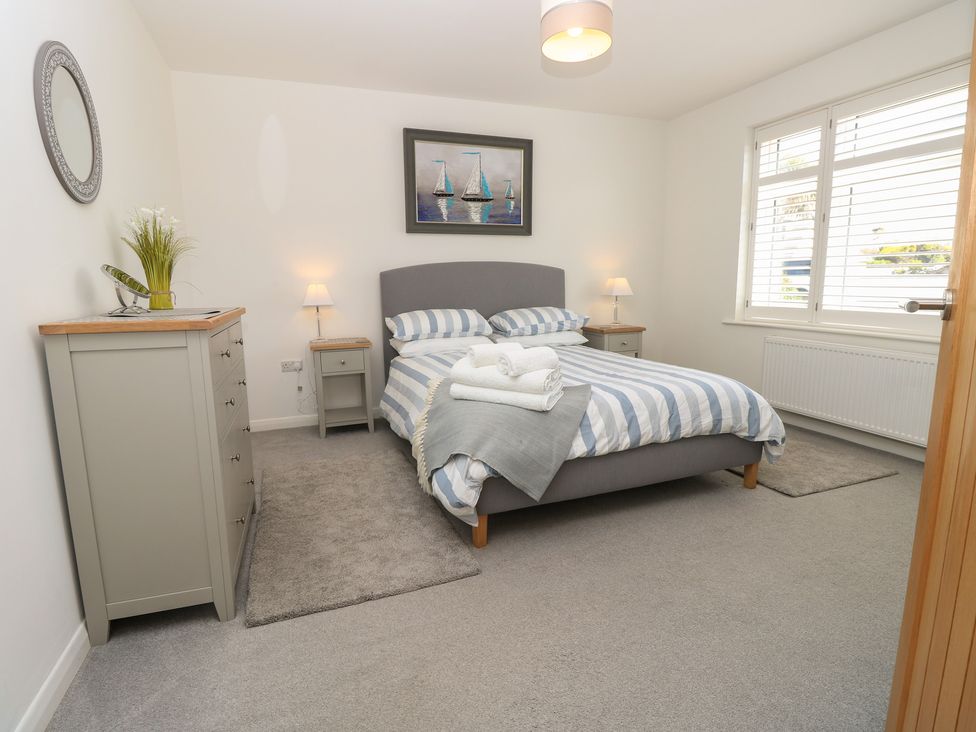 A bedroom with a bed and dresser at 50 Sea Road in Milford On Sea