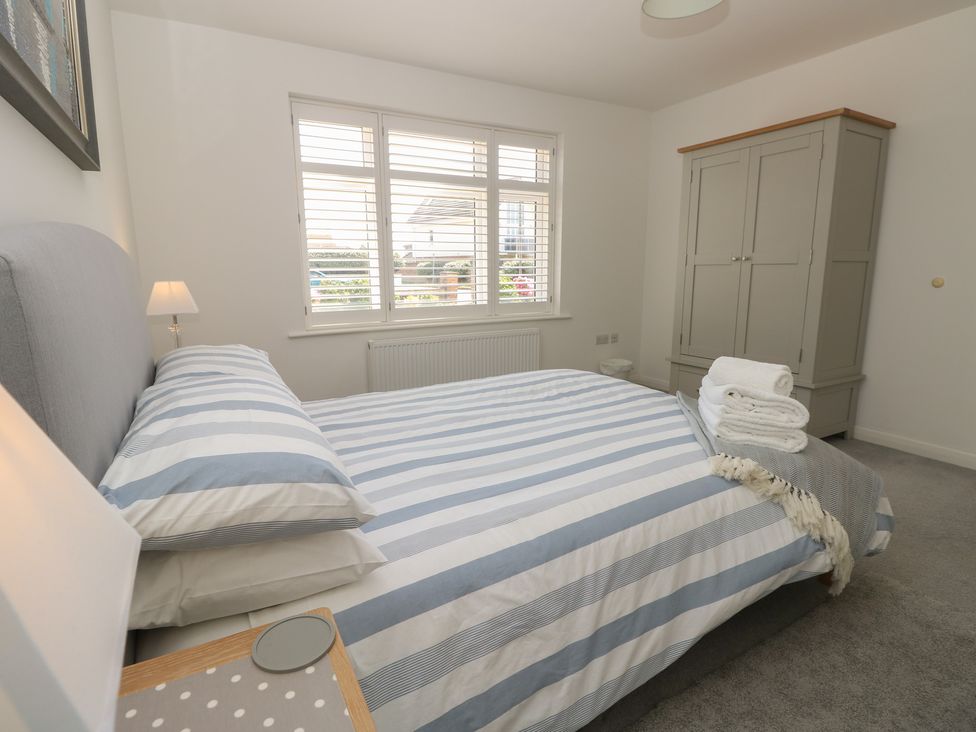 A bedroom with a bed and wardrobe at 50 Sea Road Milford On Sea