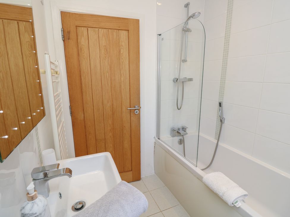 A bathroom with a shower and bathtub at 50 Sea Road in Milford On Sea