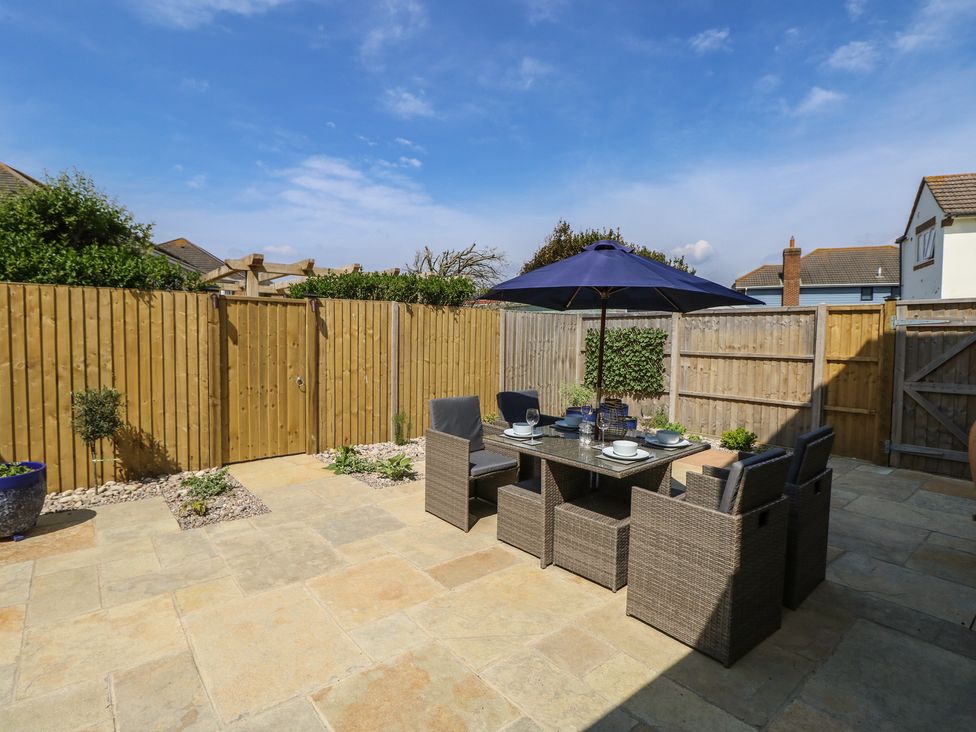 A garden with a dining table and chairs at 50 Sea Road Milford On Sea