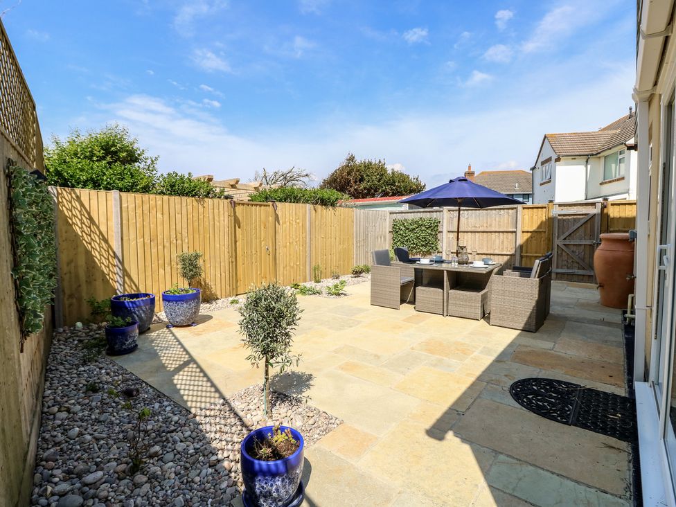 A garden with a dining table and chairs at 50 Sea Road Milford On Sea