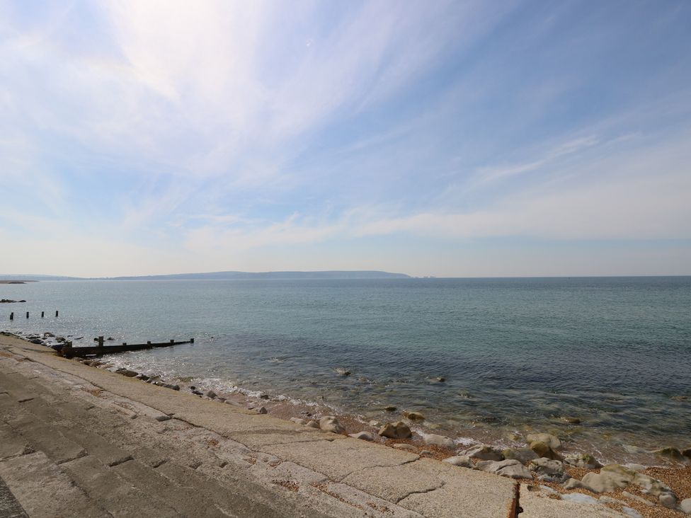 A shoreline with pebbles and a jetty at 50 Sea Road in Milford On Sea