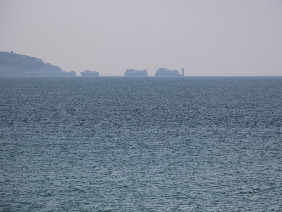 A view of the sea with distant islands and a lighthouse at 50 Sea Road Milford On Sea