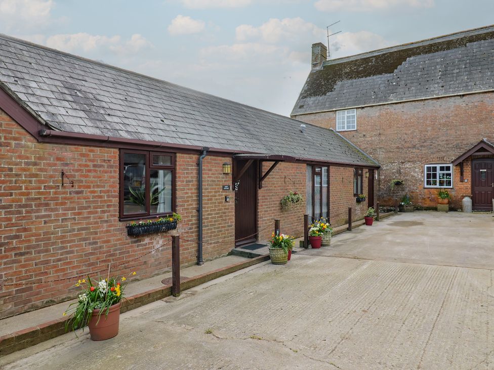 An outdoor area with brick building and planters at Daisy Cottage Whitchurch Canonicorum near Charmouth
