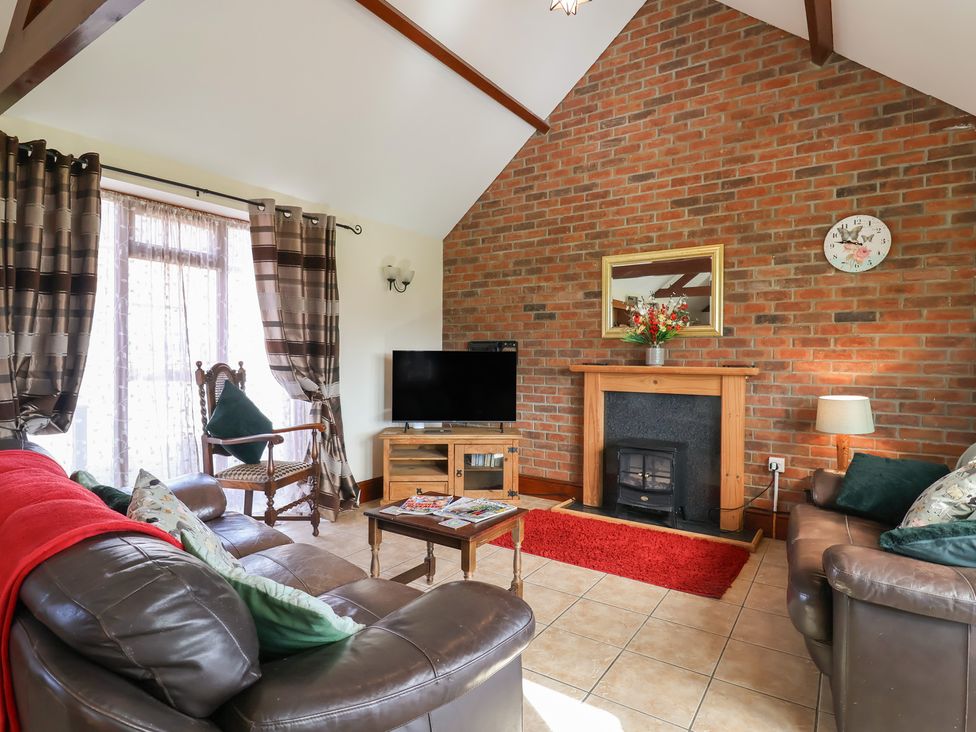 A living room with a fireplace and sofa at Daisy Cottage in Whitchurch Canonicorum near Charmouth