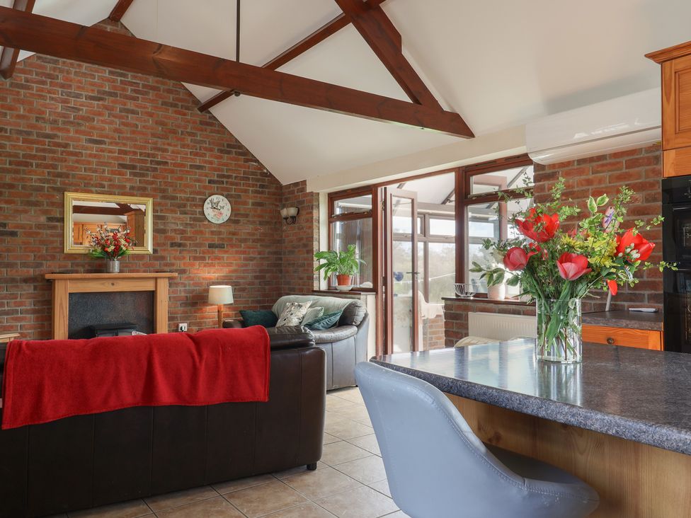 A living room with a brick wall and sofa at Daisy Cottage Whitchurch Canonicorum near Charmouth