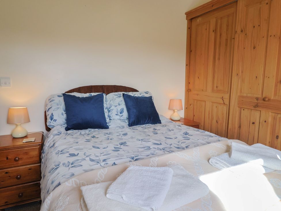 A bedroom with a bed and bedside lamp at Daisy Cottage in Whitchurch Canonicorum near Charmouth