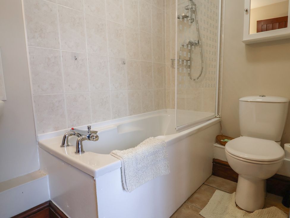 A bathroom with a bathtub and shower enclosure at Daisy Cottage Whitchurch Canonicorum near Charmouth