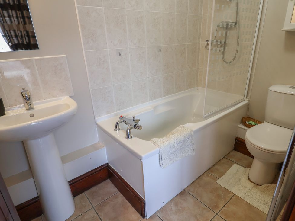 A bathroom with a bath tub, shower, sink, and toilet at Daisy Cottage Whitchurch Canonicorum near Charmouth