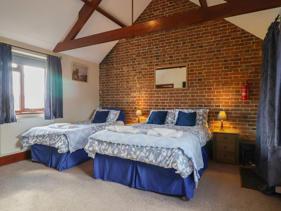 A bedroom with two beds and a window at Daisy Cottage in Whitchurch Canonicorum near Charmouth
