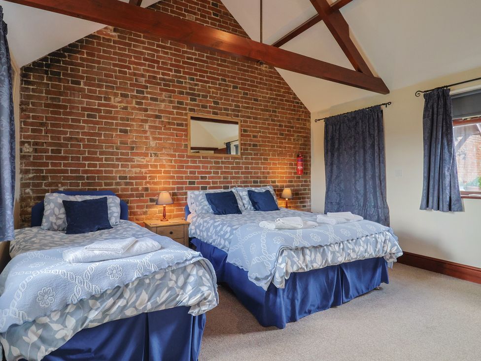 A bedroom with two beds and a mirror at Daisy Cottage Whitchurch Canonicorum near Charmouth