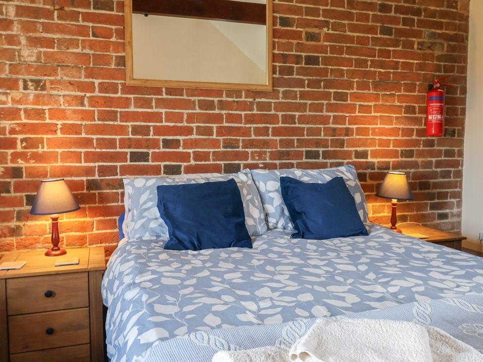 A bedroom with a bed and lamps on nightstands at Daisy Cottage near Whitchurch Canonicorum