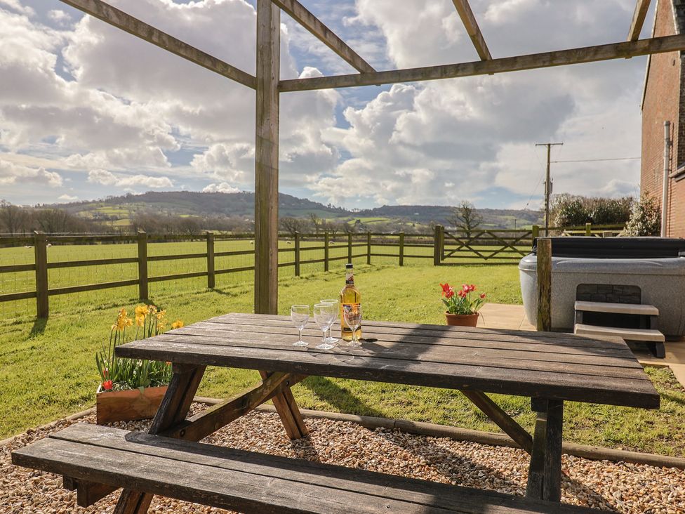 An outdoor area with a picnic table and hot tub at Daisy Cottage Whitchurch Canonicorum near Charmouth