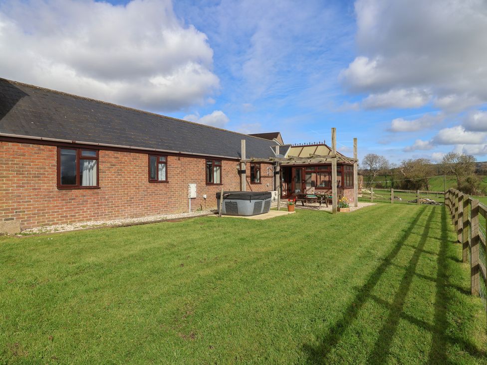 A garden with a hot tub and fence at Daisy Cottage Whitchurch Canonicorum near Charmouth