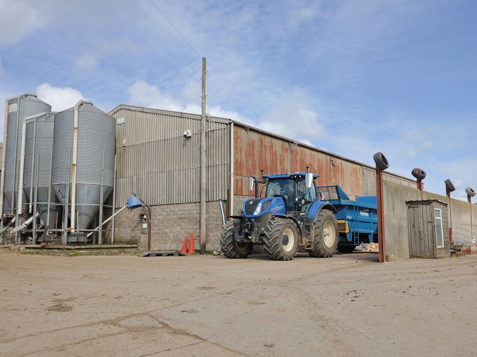 A tractor and storage silos at a farm at Daisy Cottage in Whitchurch Canonicorum near Charmouth