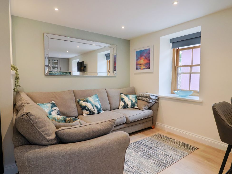 A living room with a sofa and window at Flat 2 The Cedars in Lyme Regis