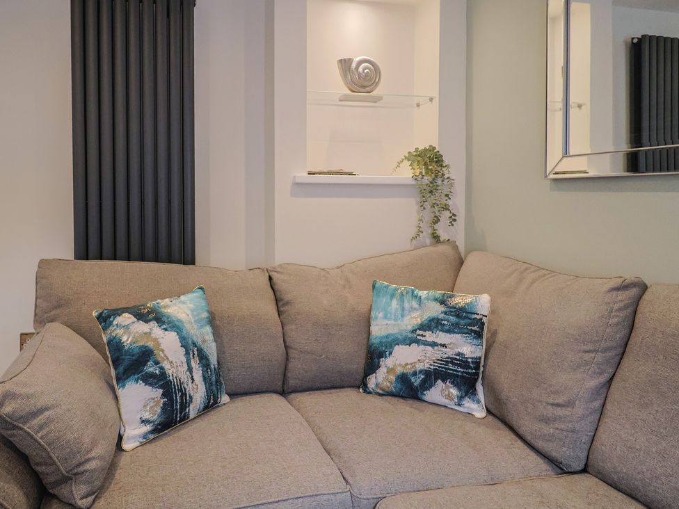 A living room with a gray sofa and decorative items at Flat 2 The Cedars Lyme Regis