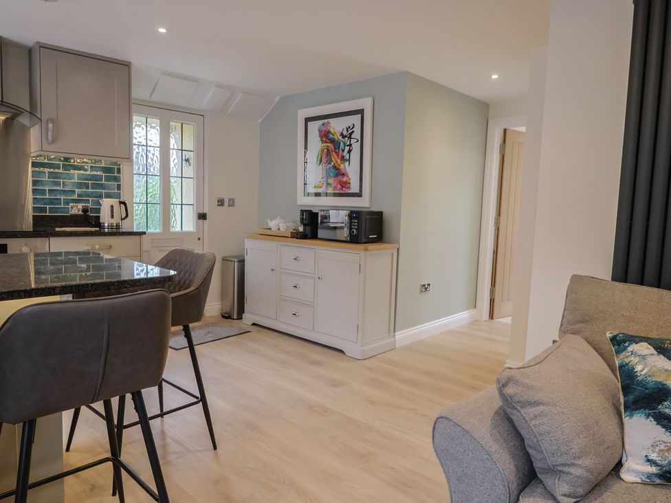 A kitchen with bar stools and a cabinet at Flat 2 The Cedars in Lyme Regis