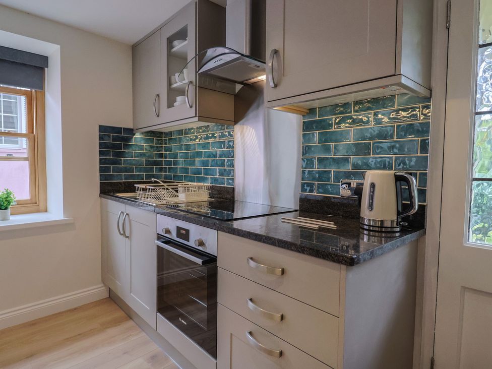 A kitchen with cabinets and appliances at Flat 2 The Cedars Lyme Regis