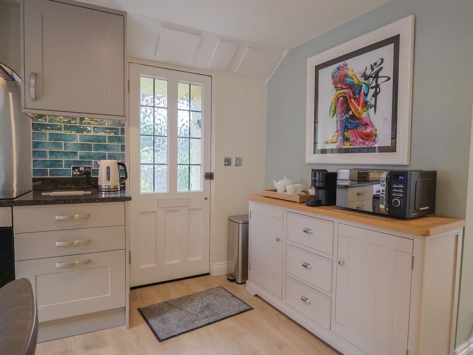 A kitchen with appliances and a door at Flat 2 The Cedars Lyme Regis