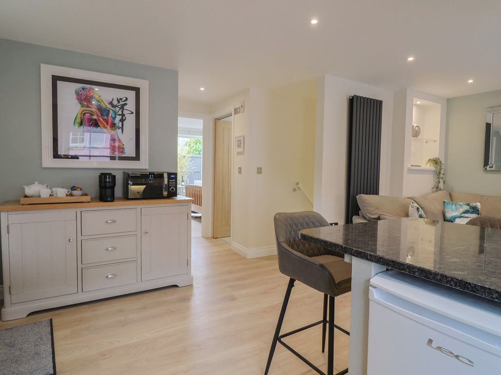 A kitchen with a coffee maker and artwork on the wall at Flat 2 The Cedars Lyme Regis