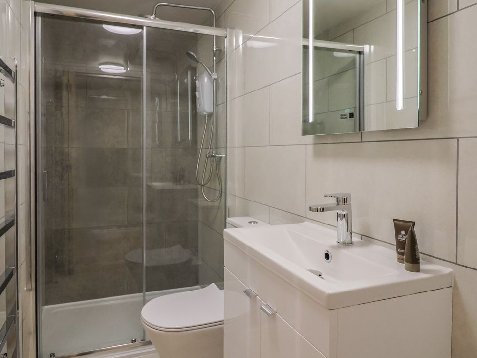 A bathroom with shower, sink, and toilet at Flat 2 The Cedars in Lyme Regis