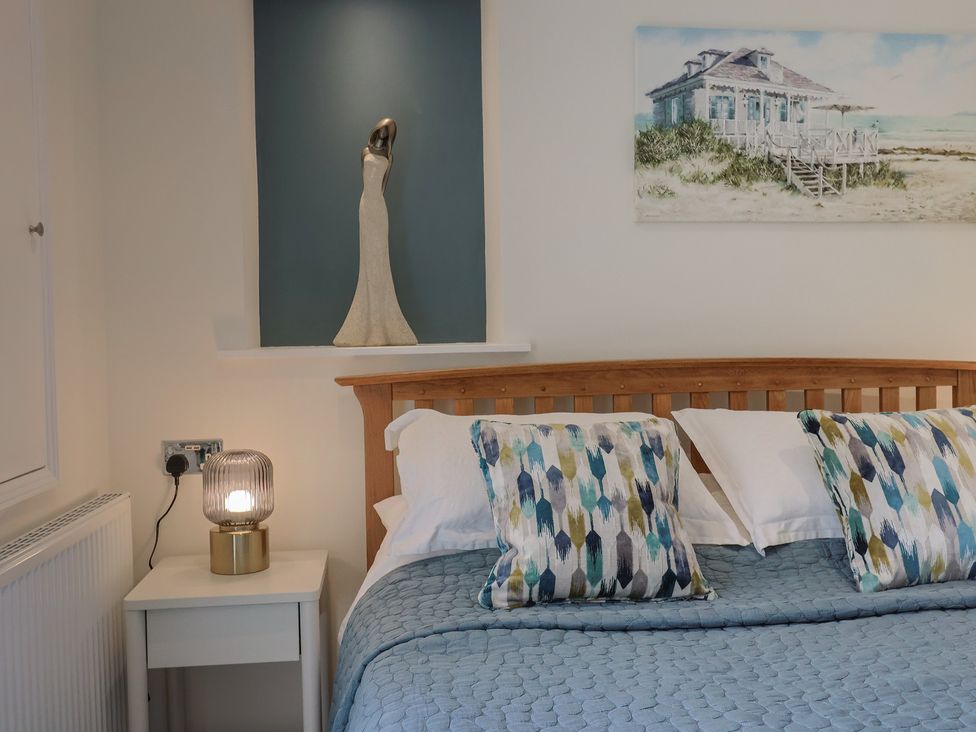 A bedroom with a bed and wall art at Flat 2 The Cedars Lyme Regis