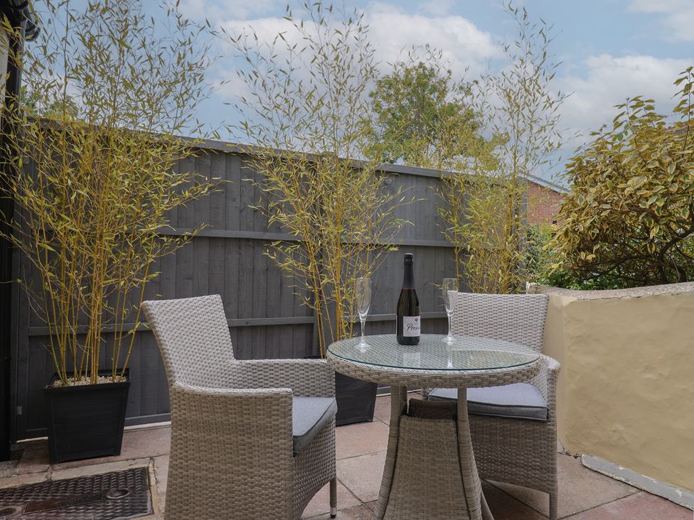 An outdoor seating area with a table and chairs at Flat 2 The Cedars in Lyme Regis