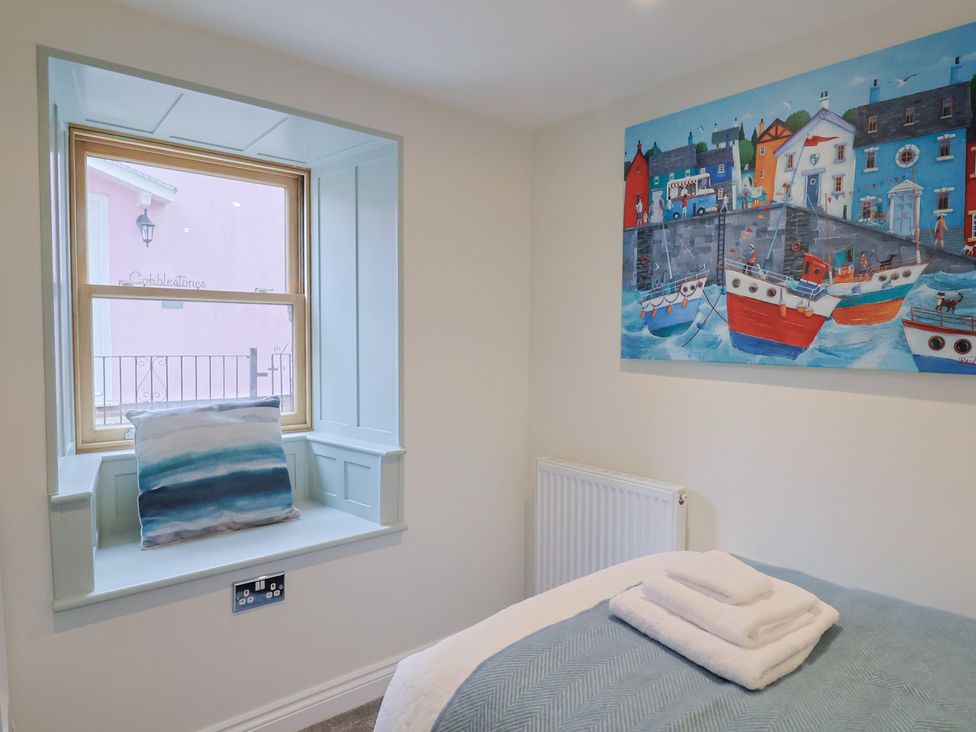 A bedroom with a window and a painting at Flat 2 The Cedars Lyme Regis