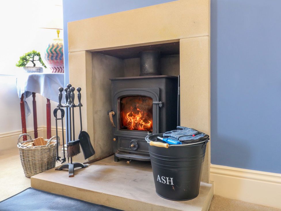 A living room with a fireplace and ash bucket at 2A Water Street, Bakewell