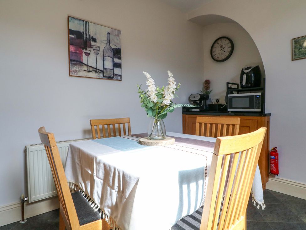 A dining room with a table and chairs at 2A Water Street in Bakewell