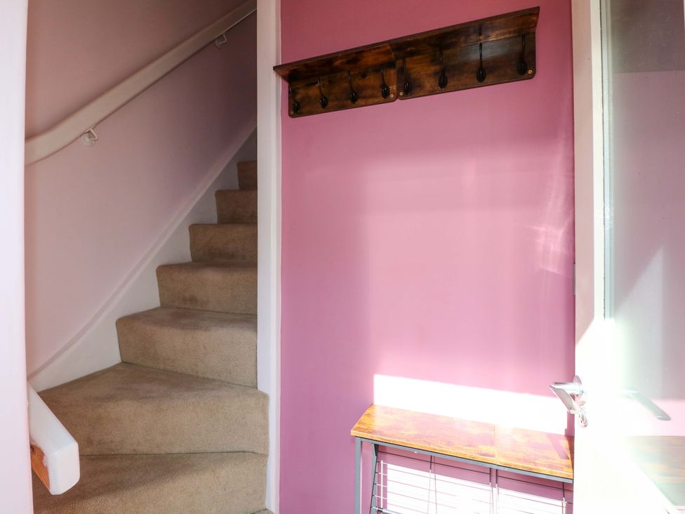 A hallway with stairs and a coat rack at 2A Water Street Bakewell