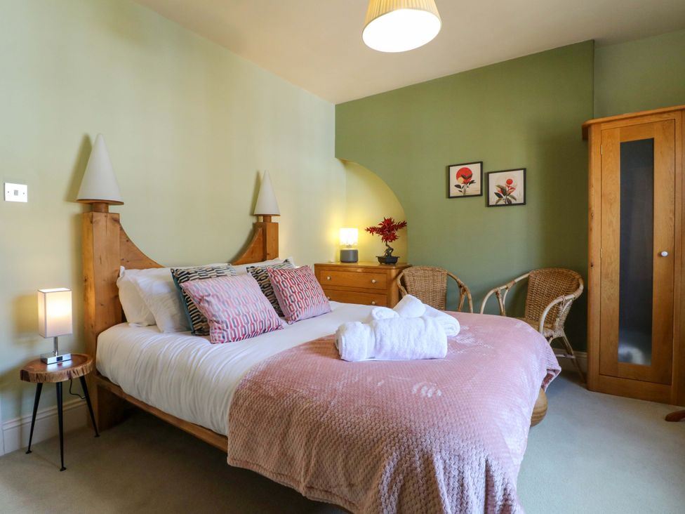 A bedroom with a bed and wooden furniture at 2A Water Street, Bakewell