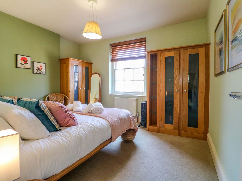 A bedroom with a bed and wardrobe at 2A Water Street in Bakewell
