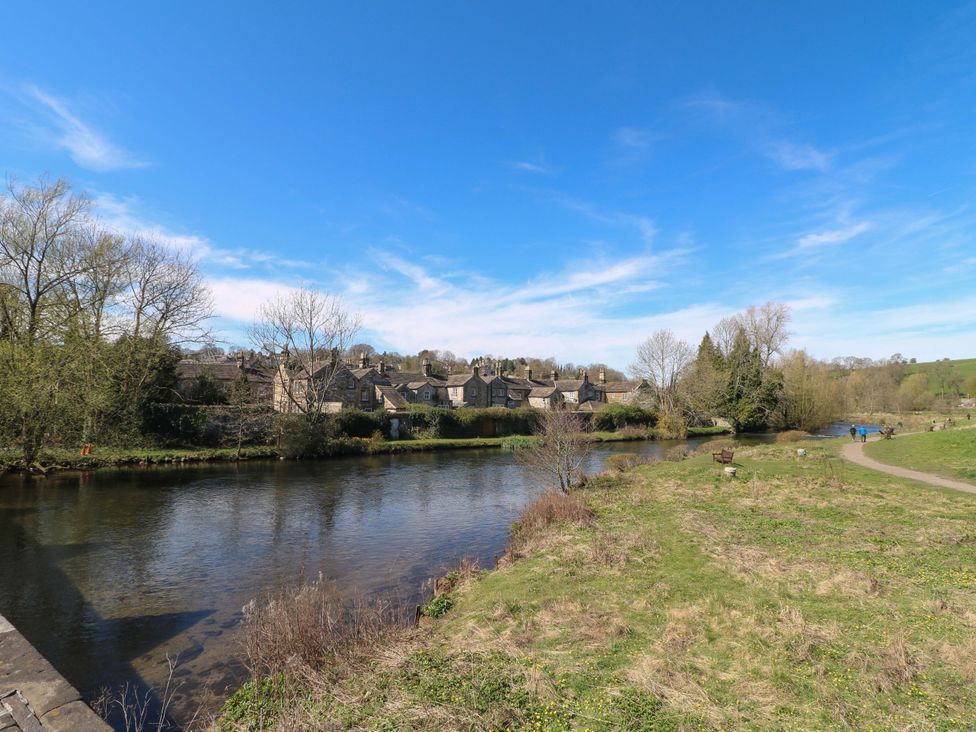 A river with houses and a pathway in Bakewell