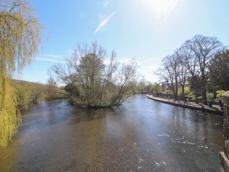 A river surrounded by trees with a pathway and people at 2A Water Street Bakewell