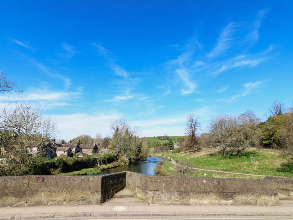 A landscape view with houses beside a river and trees at 2A Water Street Bakewell